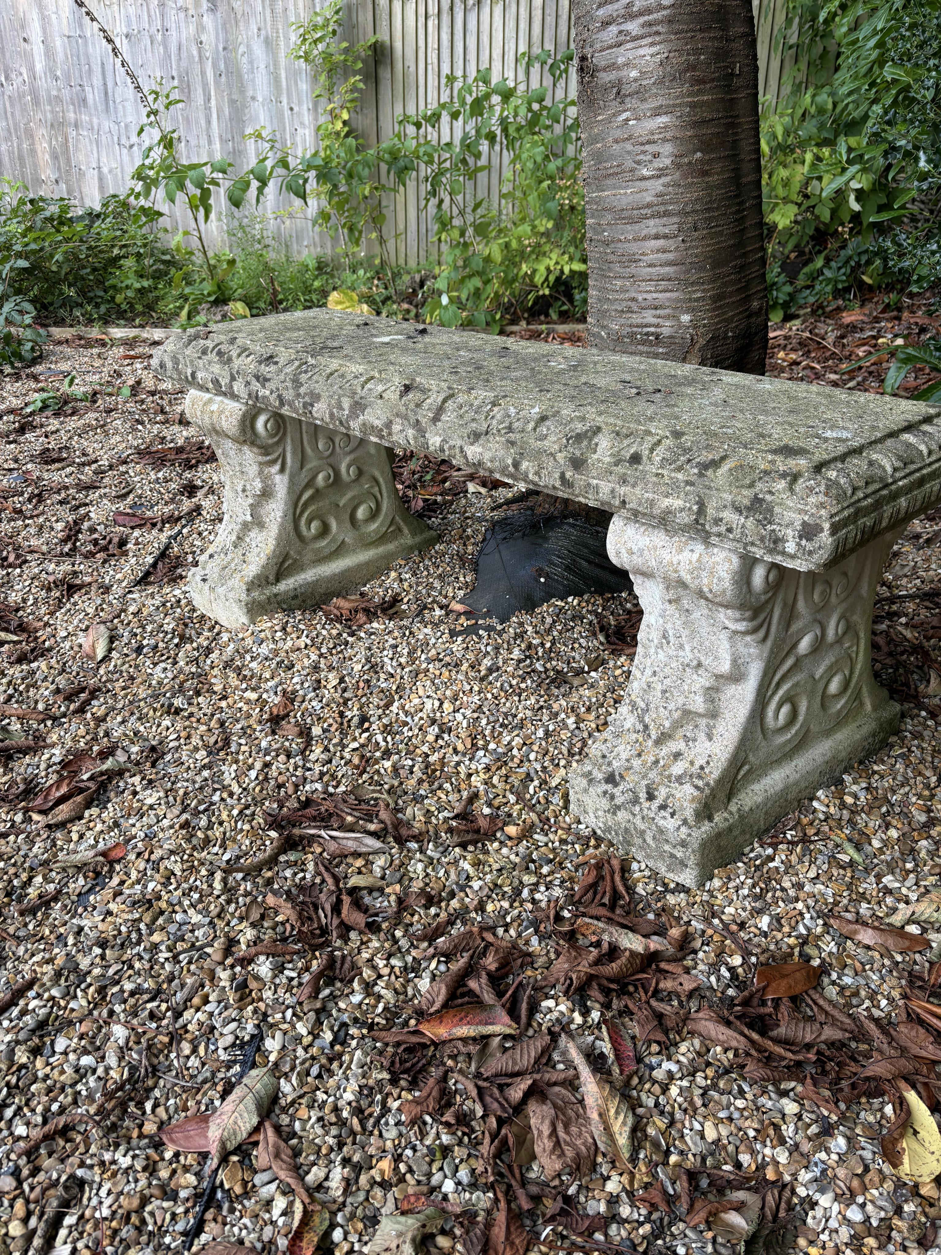 Two reconstituted stone benches, one curved, width 110cm, height 40cm, the other straight, width 114cm, height 44cm. Condition - both weathered, otherwise good condition